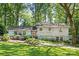Charming two-story home with grey siding, red door, beautiful landscaping, and mature trees at 3329 Winnipeg Cir, Charlotte, NC 28210