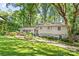 Charming two-story home with grey siding, red door, beautiful landscaping, and mature trees at 3329 Winnipeg Cir, Charlotte, NC 28210