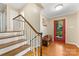 Foyer featuring wood floors, staircase, and red front door at 3329 Winnipeg Cir, Charlotte, NC 28210