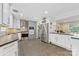 Open kitchen featuring stainless steel appliances, white cabinets, and adjacent dining and living spaces at 3329 Winnipeg Cir, Charlotte, NC 28210