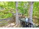 Inviting outdoor dining area on a deck, surrounded by mature trees and lush greenery at 3329 Winnipeg Cir, Charlotte, NC 28210