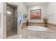 A primary bathroom featuring a tiled shower, soaker tub with tile surround and tiled wainscotting at 3398 Millstone Creek Rd, Lancaster, SC 29720