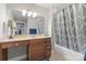 Bathroom featuring a vanity with ample storage, a well-lit mirror, and a shower with a patterned curtain at 3398 Millstone Creek Rd, Lancaster, SC 29720