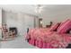 Cozy bedroom design featuring red patterned bedding, light gray carpet, a ceiling fan, and rocking chair at 3398 Millstone Creek Rd, Lancaster, SC 29720