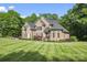 Elegant brick home with a manicured lawn and lush landscaping offers charming curb appeal at 3398 Millstone Creek Rd, Lancaster, SC 29720