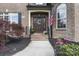 Charming brick home entry with wood door, American flag, and landscaped front yard at 3398 Millstone Creek Rd, Lancaster, SC 29720