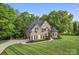 Stately brick home with lush lawn, manicured landscaping, and a winding driveway at 3398 Millstone Creek Rd, Lancaster, SC 29720