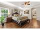 This main bedroom features a tray ceiling, hardwood floors, and entry to the ensuite bathroom at 3398 Millstone Creek Rd, Lancaster, SC 29720