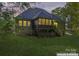 A brick home at dusk showcasing a screened-in porch and well-maintained backyard at 3398 Millstone Creek Rd, Lancaster, SC 29720