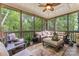 Relaxing screened in sunroom with ample seating and beautiful views of a forest at 3398 Millstone Creek Rd, Lancaster, SC 29720