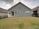 A backyard with a well-maintained lawn, a patio, and a view of the property's exterior at 4027 Gozzi Dr, Iron Station, NC 28080
