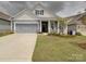 Charming home featuring a two-car garage, inviting front porch, and manicured lawn at 4027 Gozzi Dr, Iron Station, NC 28080