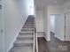 Carpeted staircase featuring a convenient mudroom bench near the entryway at 4027 Gozzi Dr, Iron Station, NC 28080