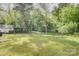 Expansive backyard features a lush lawn surrounded by mature trees, offering privacy at 405 Belva St, Kannapolis, NC 28081