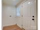 Bright laundry room with white walls, wood trim, wood laminate flooring and exterior door at 405 Belva St, Kannapolis, NC 28081