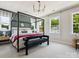 Serene bedroom with a canopy bed, neutral tones, and ample natural light from multiple windows at 411 Old Town Village Rd, Waxhaw, NC 28173
