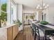 Bright dining room with hardwood floors, a large window, and elegant lighting fixtures overlooking the connected kitchen at 411 Old Town Village Rd, Waxhaw, NC 28173