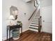 Welcoming foyer with dark wood floors, stairs, table, and a decorative mirror at 411 Old Town Village Rd, Waxhaw, NC 28173