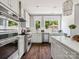 Well-lit kitchen with stainless steel appliances, white cabinetry, and a view to the backyard through large windows at 411 Old Town Village Rd, Waxhaw, NC 28173