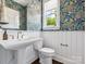 Stylish powder room featuring designer wallpaper, white wainscoting, and a classic pedestal sink at 411 Old Town Village Rd, Waxhaw, NC 28173