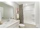 Bright bathroom with a combination tub and shower, decor, and neutral wall paint at 4248 Black Ct # 232, Harrisburg, NC 28075