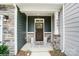 Inviting front porch with stone pillars, a stylish front door, and decorative lanterns at 4248 Black Ct # 232, Harrisburg, NC 28075