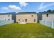 The expansive backyard is enclosed with a white fence and has a grassy lawn and patio at 4439 Wild Ridge Dr, Charlotte, NC 28215