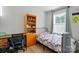 A bright bedroom with a bed, desk, and storage, offering a functional living space at 4439 Wild Ridge Dr, Charlotte, NC 28215