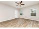 Bright bedroom with a ceiling fan, hardwood flooring, and natural light from two windows at 5053 Arbordale Way, Mount Holly, NC 28120