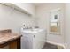 Laundry room with modern washer and dryer, storage shelves, and a window at 5053 Arbordale Way, Mount Holly, NC 28120