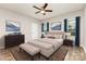 Bedroom with soft lighting, ceiling fan, neutral walls, and complementing blue decor at 5053 Arbordale Way, Mount Holly, NC 28120