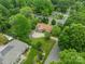 Aerial view of a home with a well-maintained lawn, mature trees, driveway, and detached garage at 5522 Sharon Rd, Charlotte, NC 28210