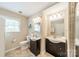 Bright bathroom with double sinks, ample counter space, a toilet, and a window, ensuring a comfortable experience at 5522 Sharon Rd, Charlotte, NC 28210