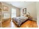 Cozy bedroom with hardwood floors, a ceiling fan, a comfortable bed, and a relaxing reading chair at 5522 Sharon Rd, Charlotte, NC 28210