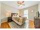 Cozy bedroom features hardwood floors, neutral walls, and a comfortable bed with stylish linens and a ceiling fan at 5522 Sharon Rd, Charlotte, NC 28210