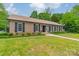 Charming brick home featuring a well-manicured lawn, classic shutters, and lush surrounding trees at 5522 Sharon Rd, Charlotte, NC 28210