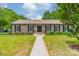 Charming brick home with a lush green lawn and manicured landscaping in front at 5522 Sharon Rd, Charlotte, NC 28210