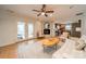 Bright living room with white brick fireplace, ceiling fan, tile floors, and direct access to kitchen at 5522 Sharon Rd, Charlotte, NC 28210