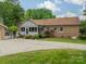 Rear view of brick house with screened porch and driveway to a two-car detached garage at 5522 Sharon Rd, Charlotte, NC 28210