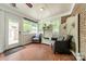 Inviting sunroom featuring a brick accent wall and terra cotta tile flooring with a decorative bench and seating area at 5522 Sharon Rd, Charlotte, NC 28210