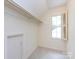 Cozy attic space featuring a window with shutters and ample storage space with a door at 6007 Patrick Pl, Charlotte, NC 28210