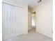 Neutral bedroom featuring light carpet, double closet doors, and bright natural light from the door at 6007 Patrick Pl, Charlotte, NC 28210