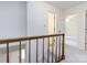Bright hallway features a wooden banister, neutral walls, and doorways leading to various rooms, carpeted flooring at 6007 Patrick Pl, Charlotte, NC 28210