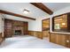 Cozy living room with a brick fireplace, built-in shelving, and wood-paneled walls at 6007 Patrick Pl, Charlotte, NC 28210