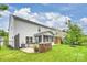 A well-manicured backyard, showcasing a screened-in porch and a stone-lined spa area at 7209 Brookline Pl, Huntersville, NC 28078