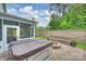 Backyard with a hot tub, screened porch, stone retaining wall, built-in seating, and a fire pit at 7209 Brookline Pl, Huntersville, NC 28078