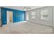 Large bedroom featuring a blue accent wall, carpeted floor, and natural light from windows at 7209 Brookline Pl, Huntersville, NC 28078