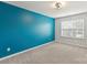Bright bedroom featuring a blue accent wall and natural light from the window at 7209 Brookline Pl, Huntersville, NC 28078
