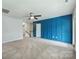 Open bedroom area featuring blue wall decor, neutral carpet, and a ceiling fan at 7209 Brookline Pl, Huntersville, NC 28078