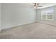 Neutral-toned bedroom with ceiling fan and a bright window with natural light at 7209 Brookline Pl, Huntersville, NC 28078